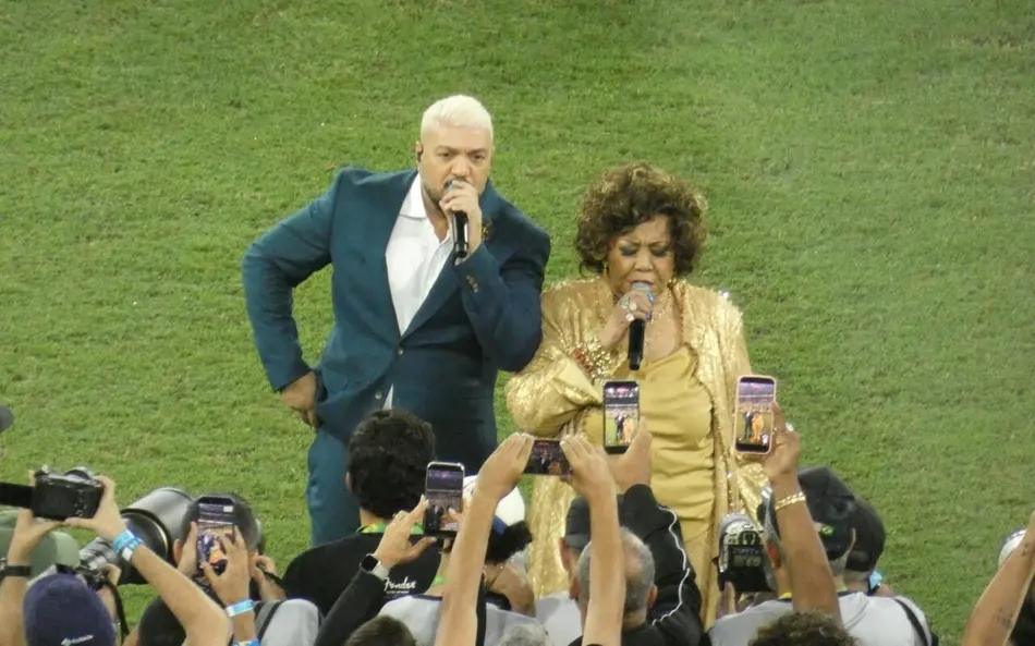 Belo e Alcione viram meme ao cantarem hino nacional em amistoso da seleção brasileira - Foto: Lucas Bayer/Lance